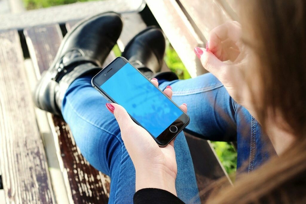 junge Frau am Smartphone Bildschirmzeit an der Uni verringern Unsere Tipps