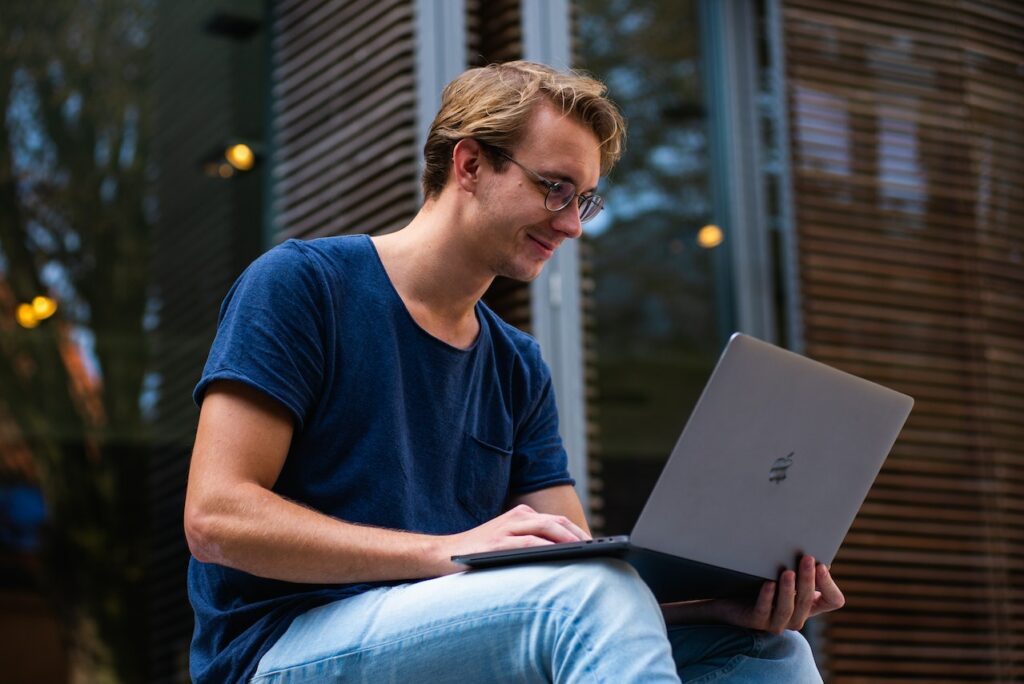 Student schaut glücklich auf seinen Laptop Studenten Spartipps - Wie man als Student Geld sparen kann