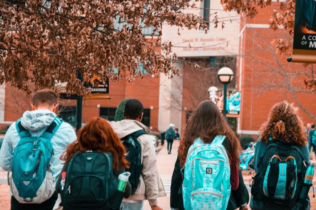 Studenten laufen mit ihren Rucksäcken zur Uni Welcher Rucksack für Uni Studiumskrempel transportieren!