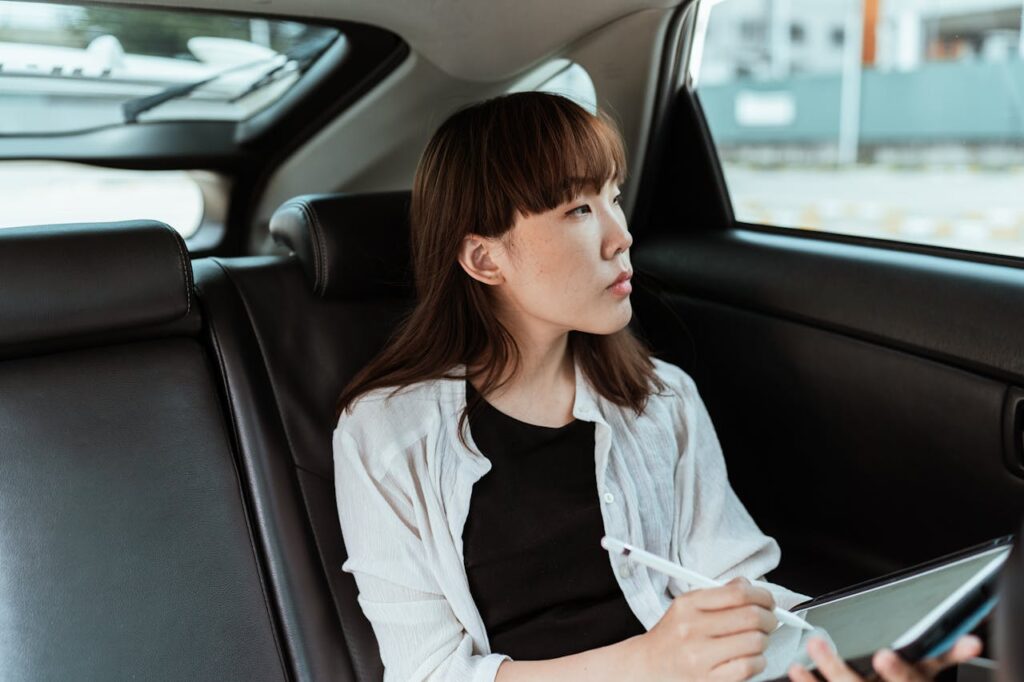 Studierende im Auto Asiatin Pendeln für das Studium – lohnt sich das
